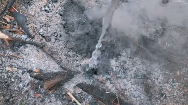 Kouření uhlíky jsou zalitá vodou z plastové láhve. Hašení požáru. — Stock video