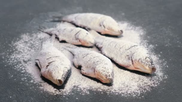 Karpfenfisch in Gewürzen und Mehl auf einem schwarzen Tisch. — Stockvideo