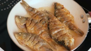 Küçük carps balık yağı bir tavada kızarmış.