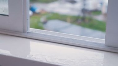 Islak pencere pervazına yağmurda, açık pencere ile yakın çekim.