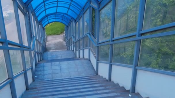 Afdaling door trappen van verhoogde voetgangersoversteekplaats van binnenuit. Veilige doorgang over de weg. — Stockvideo