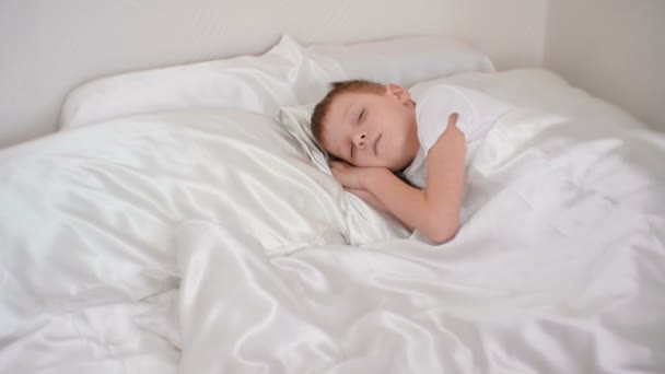 Zeven-jaar-oude jongen wakker nippen en geeuwen. — Stockvideo