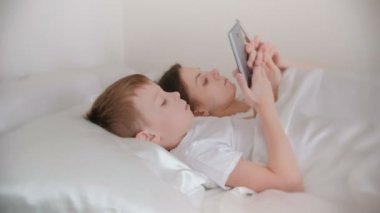Anne ve oğlu uyan ve onların hareket eden telefon içinde enterne browsing. Yan görünüm.
