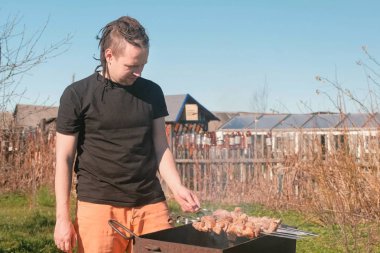 Genç erkekler aşçılar şaşlık et arka bahçesinde üzerinde kömür ızgara üzerine.