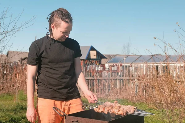 Genç erkekler aşçılar şaşlık et arka bahçesinde üzerinde kömür ızgara üzerine.