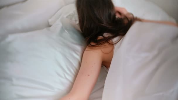 Jonge vrouw slapen in bed. Flips over naar de andere kant. — Stockvideo