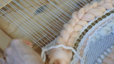 Tezgâh üzerinde dokuma. Tezgâh üzerinde dokuma. Tezgâh üzerinde çalışan kadının eller. Çerçeve ipliklerini iğne threading.