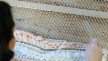 Tezgâh üzerinde dokuma. Tezgâh üzerinde çalışan kadının eller. İpliklerini iğne threading çerçeve ve tarak ile iplik tutturmak.