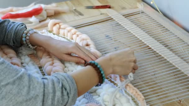 織機で織り。クローズ アップ梨花手織機で実行しているマニキュアなし。側面図です。フレームの鎖を通して針をスレッド. — ストック動画