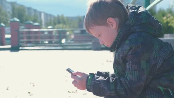 Хлопчик друкує і відправляє повідомлення на мобільний телефон . — стокове відео