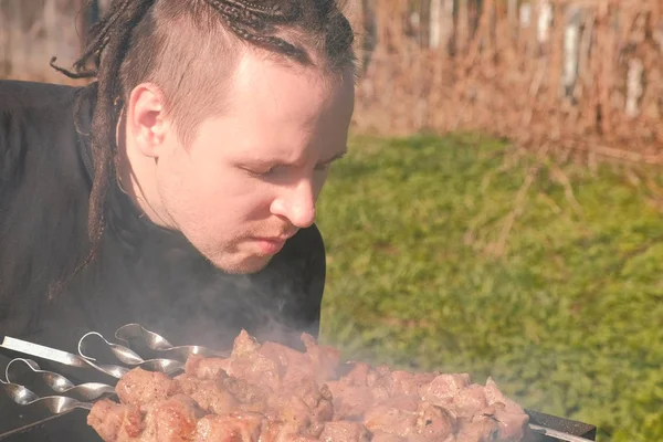 Junge Männer mit Haaren kochen Schaschlik-Fleisch auf Holzkohlegrill im Hinterhof. — Stockfoto