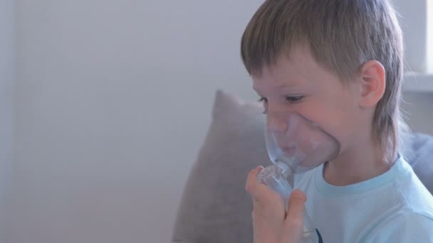Αγόρι εισπνοή μέσω της συσκευής εισπνοής μάσκα. Χρησιμοποιούν νεφελοποιητή και συσκευή εισπνοής για τη θεραπεία. — Αρχείο Βίντεο