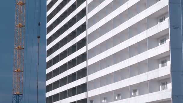 Construcción de un edificio de varios pisos. Casa y grúa de construcción en el fondo del cielo . — Vídeos de Stock