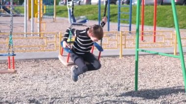 7 yaş çocuk parkta salıncakta sallanan.