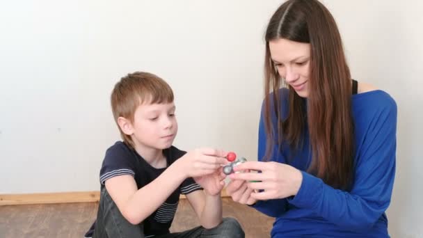 Mamá con hijo la construcción de modelos de moléculas de plástico de color conjunto de construcción . — Vídeos de Stock