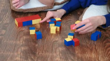 Bir tane renkli şekil küpleri oluşturma anne ve oğulları eller.