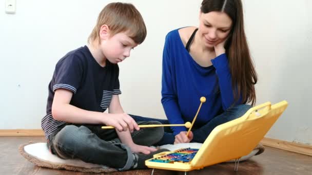 Відтворення музичного інструменту. Вчитель вчить хлопчика грати на ксилофоні — стокове відео