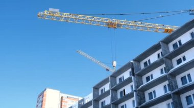 Gökyüzü arka plan üzerinde vinçler ile şantiye. Çok katlı binanın çatı Builder eserlerinden.