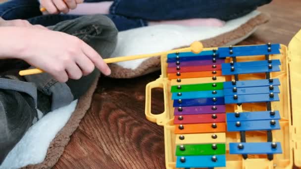 Suonare uno strumento musicale. Primo piano mamma e figli mani giocare su xilofono . — Video Stock