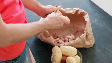 Tatlı patates soyarken oldu eller mans. Yan görünüm.