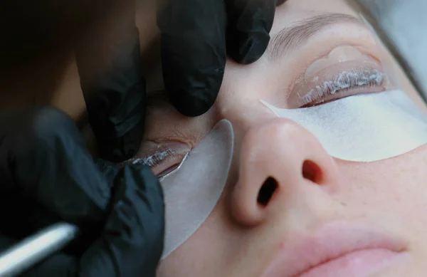 Şevval özçelik güzellik kirpikleri bir iğneyle ayırır ve onları curlers virajlı. kirpik laminasyon. Önden görünüm.