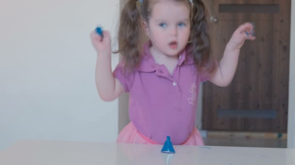 Pouco bonito menina pinta suas unhas com verniz azul . — Vídeo de Stock