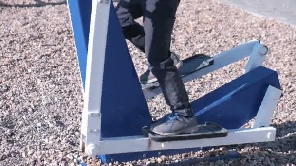 Boy está involucrado en el simulador en el parque infantil. Patas de primer plano . — Vídeos de Stock