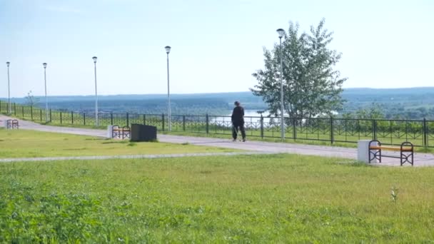 Femme engagée dans la marche nordique sur le talus de la rivière . — Video