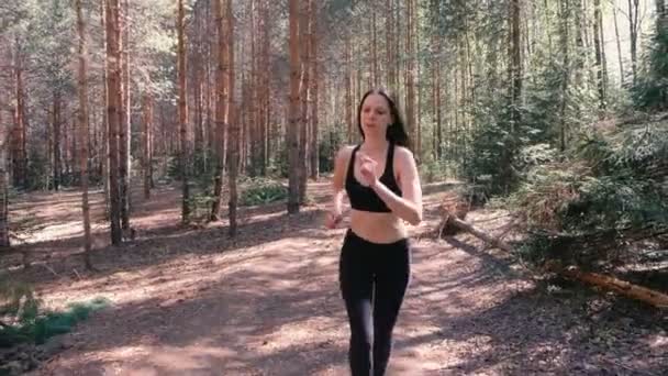 A mulher de fato desportivo está a correr no parque. Ela parou para recuperar o fôlego e restaurar o fôlego. Movimento lento . — Vídeo de Stock