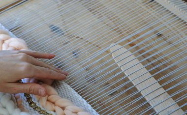 Tezgâh üzerinde dokuma. Tezgâh üzerinde çalışan kadının eller.