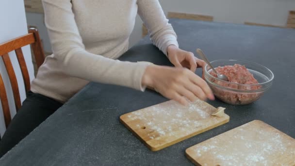 Wanita membuat pangsit dengan daging cincang, tangan tertutup . — Stok Video