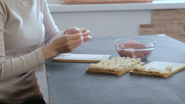 Женщина делает пельмени с мясом. Крупный план, вид сбоку . — стоковое видео