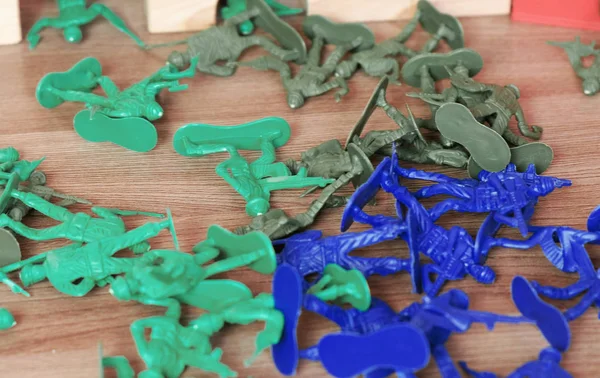 Primeros planos soldados de plástico verde y azul sobre la mesa . — Foto de Stock