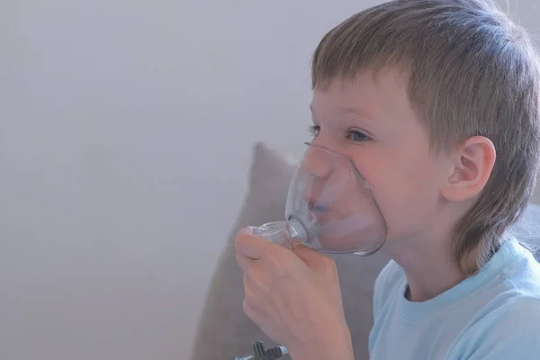 Αγόρι εισπνοή μέσω της συσκευής εισπνοής μάσκα. Χρησιμοποιούν νεφελοποιητή και συσκευή εισπνοής για τη θεραπεία. — Φωτογραφία Αρχείου