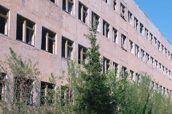 Уничтоженное заброшенное многоэтажное здание со многими разбитыми окнами . — стоковое фото