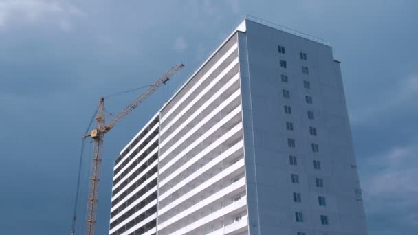 Costruzione di un edificio a più piani. Casa e costruzione gru su sfondo cielo . — Video Stock