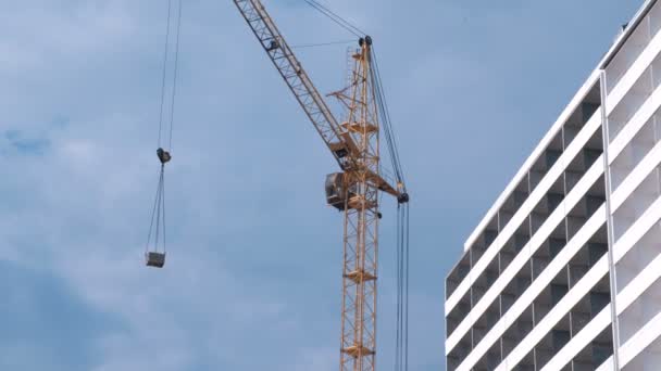 Construção de um edifício de vários andares. Casa e construção guindaste no fundo do céu . — Vídeo de Stock