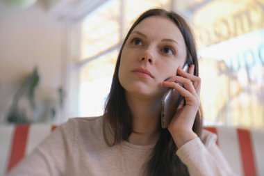 Genç güzel kadın esmer çağırır ve cep telefonu kafe ve arkadaşları bekliyorum cevap bekler.