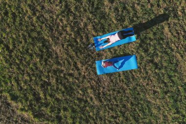 Anne sahada mindere sıcak yaz günü içinde uzanan küçük kızıyla birlikte. Havadan panoramik görünümü.