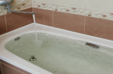 Su küvet içine dökülür. Tam bir banyo. Yakın çekim.