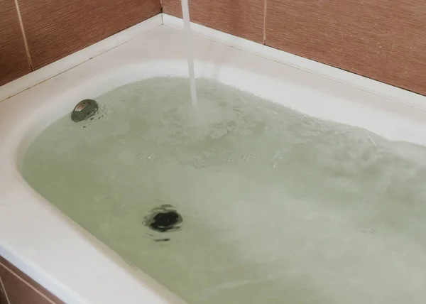 Vatten hälls i badkaret. Full bad. Närbild. — Stockfoto