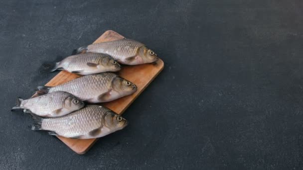 Cocinar pescado. Pequeñas carpas frescas sobre la mesa en un primer plano de madera . — Vídeos de Stock