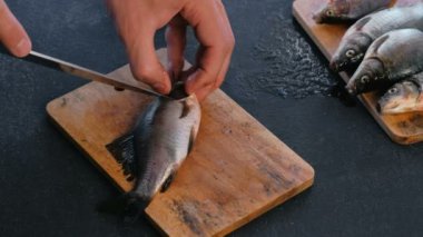 Adam balık solungaçları sazan keser. Balık pişirme. Eller yakın çekim.