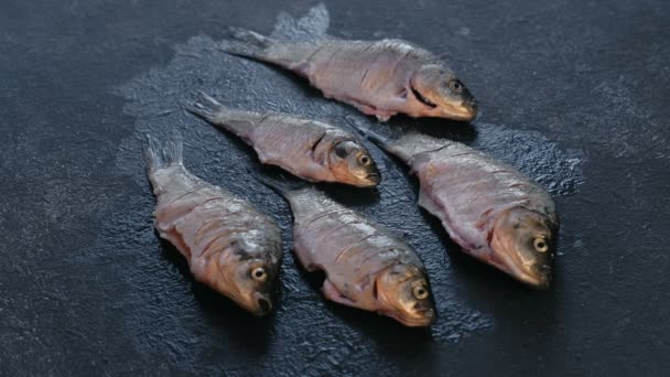 新鮮な洗浄の鯉は黒いテーブルの上の塩を振りかける. — ストック動画