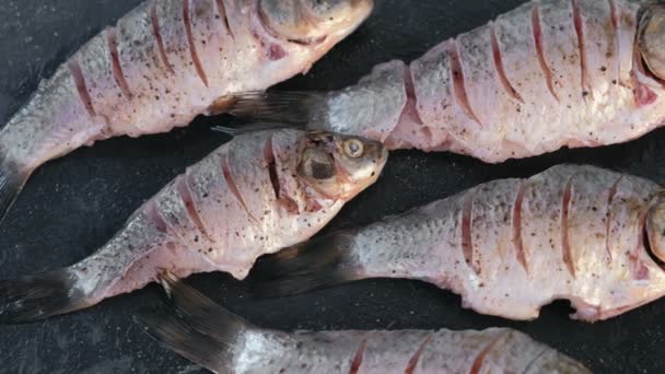 Carp in spices on a black table close-up. Top view. — Stock Video