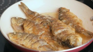 Küçük carps balık yağı bir tavada kızarmış. Yan görünüm.