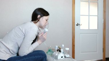 Nebulizatör ve astım tedavisi için kullanın. Genç kadın inhaler maskesi teneffüs edilmesi. Yan görünüm.