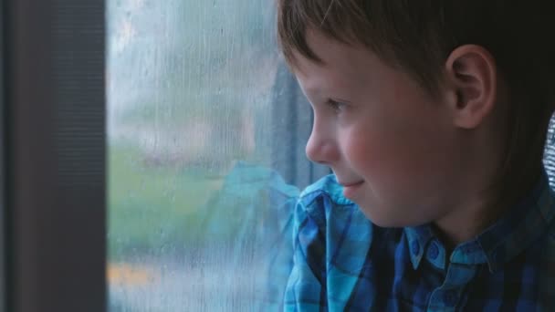 少年は雨の中窓の外に見えるし は悲しい — ストック動画