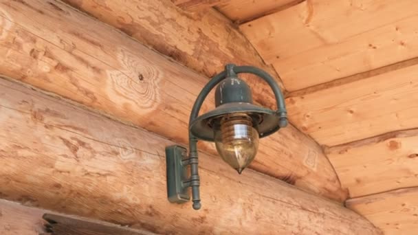 Lamp on the log house of chopped logs. — Stock Video