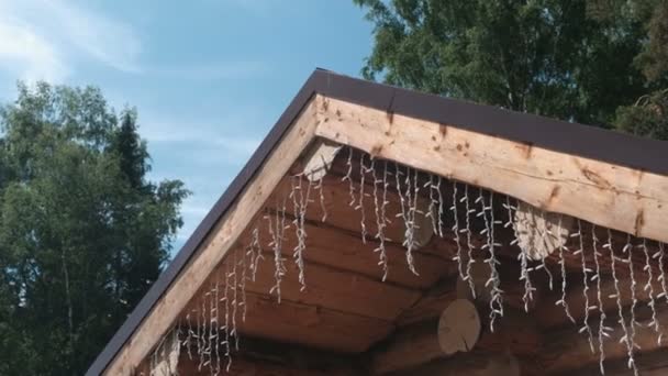 Garlands on the roof of a log house. — Stock Video